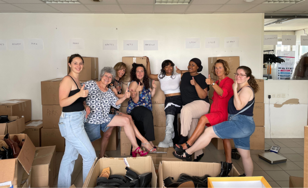Photo d'un groupe de personnes devant des piles de cartons